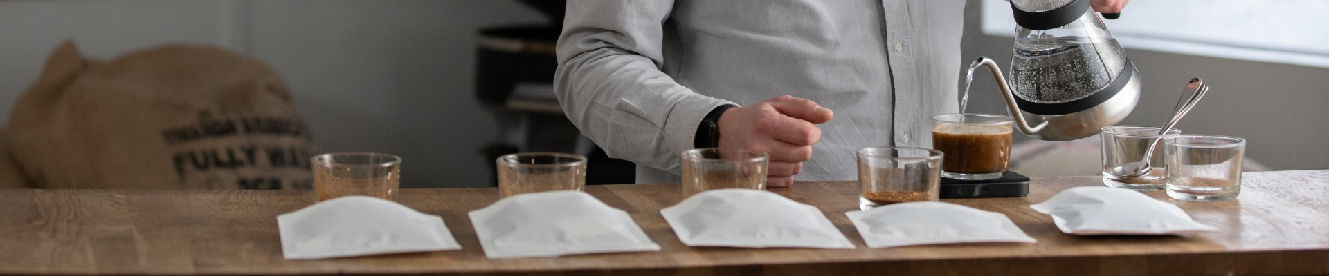 Lindy hælder vand op i en glas. Der forberedes til cupping af fem forskellige risteprofiler.