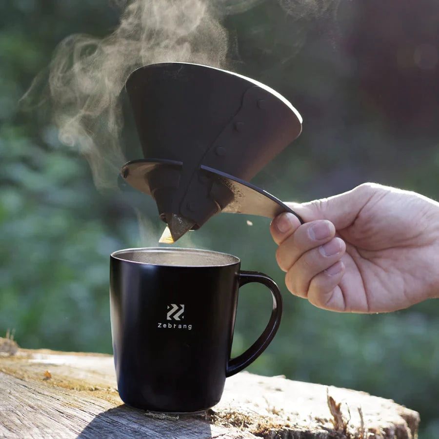 Detaljebillede af håndbryg med Harios Zebrang dripper i naturen.