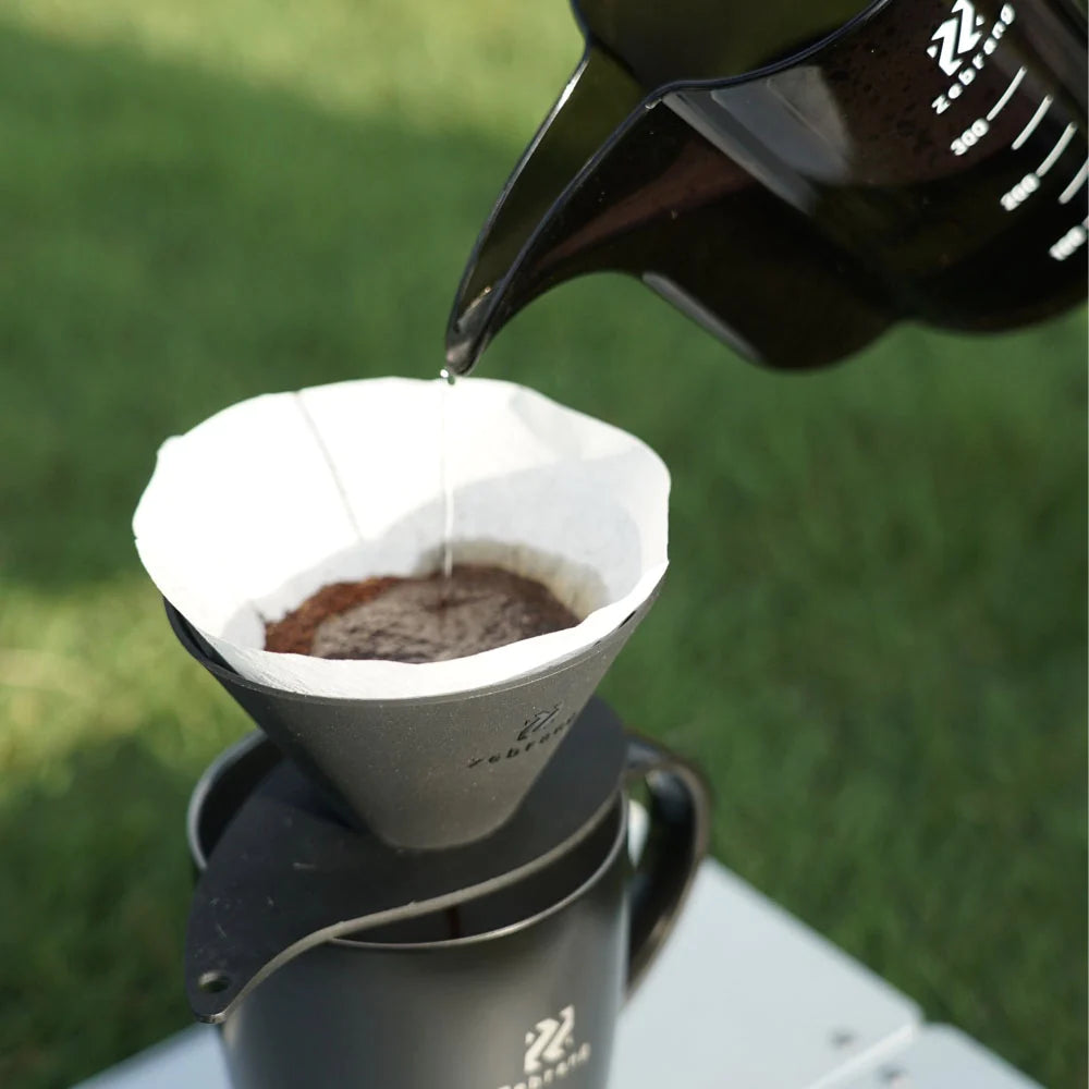 Sløret billede af håndbryg med Harios Zebrang dripper i naturen.