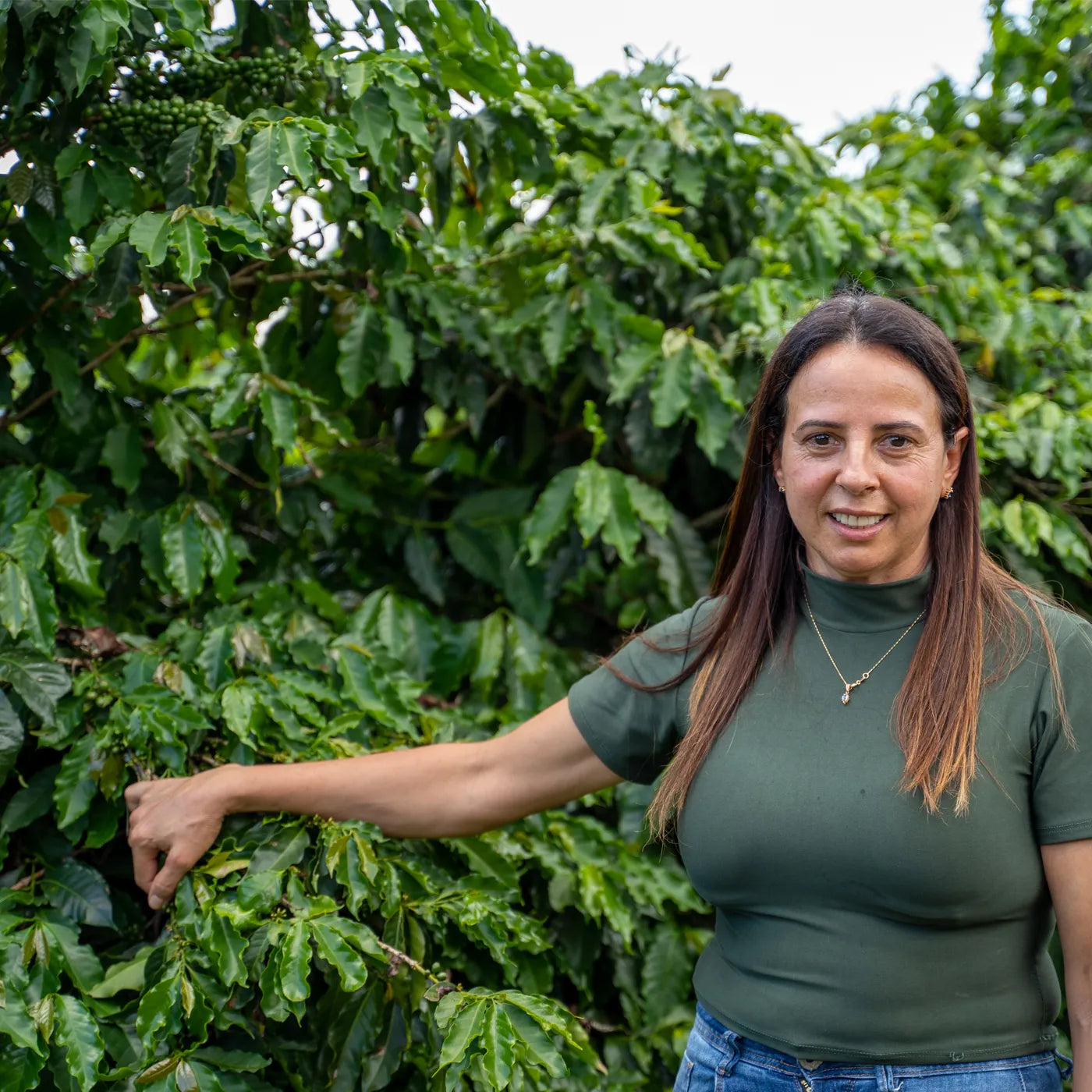 Kaffeproducent poserende med kaffeplante i forbindelse med SanCoffees Nascentes projekt i Brazil.