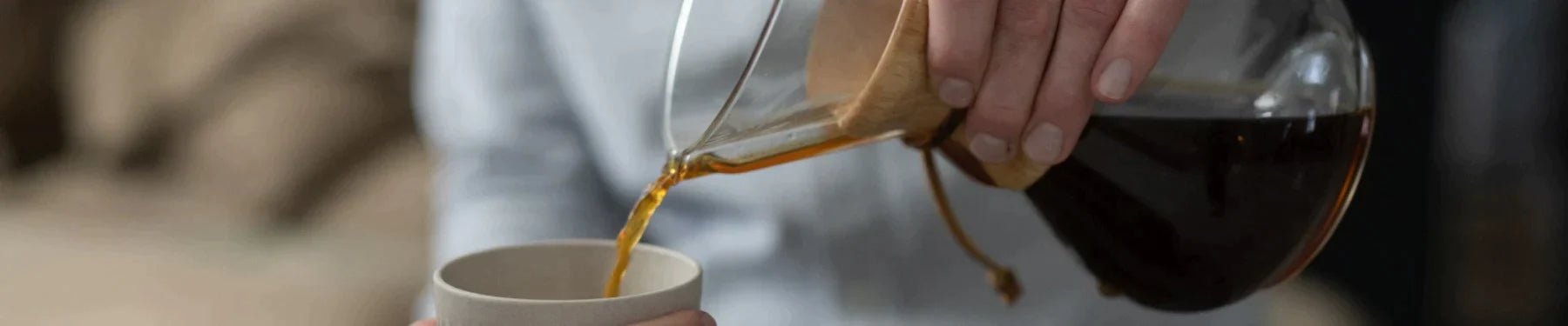 Lindy hælder brygget kaffe op i en kop, lavet på en Chemex håndbrygger.