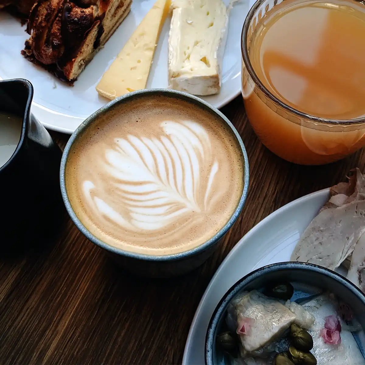 kaffekop med latteart på morgenmadsbord 